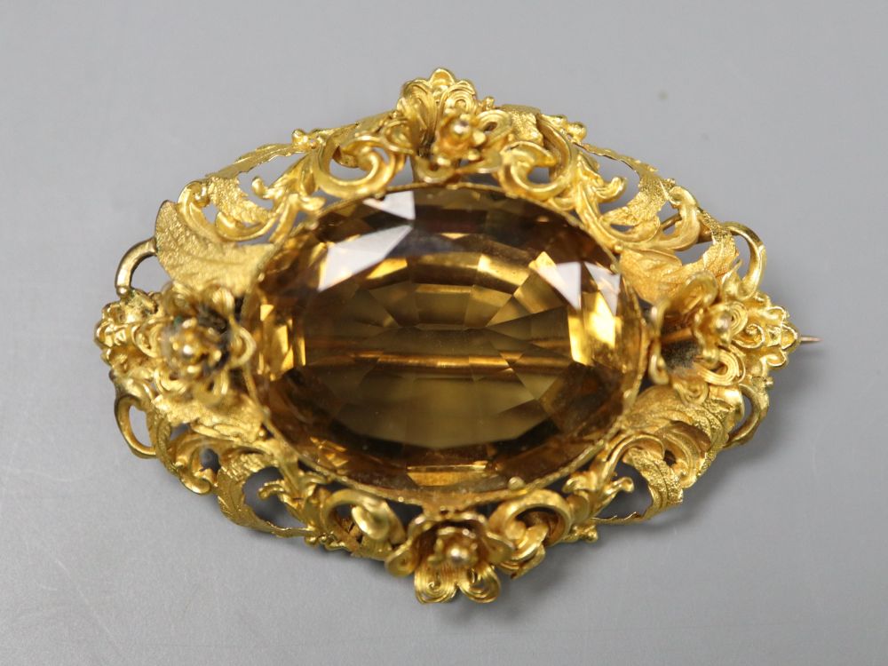 A Victorian pierced yellow metal and citrine set oval brooch, 47mm, gross 12.9 grams.